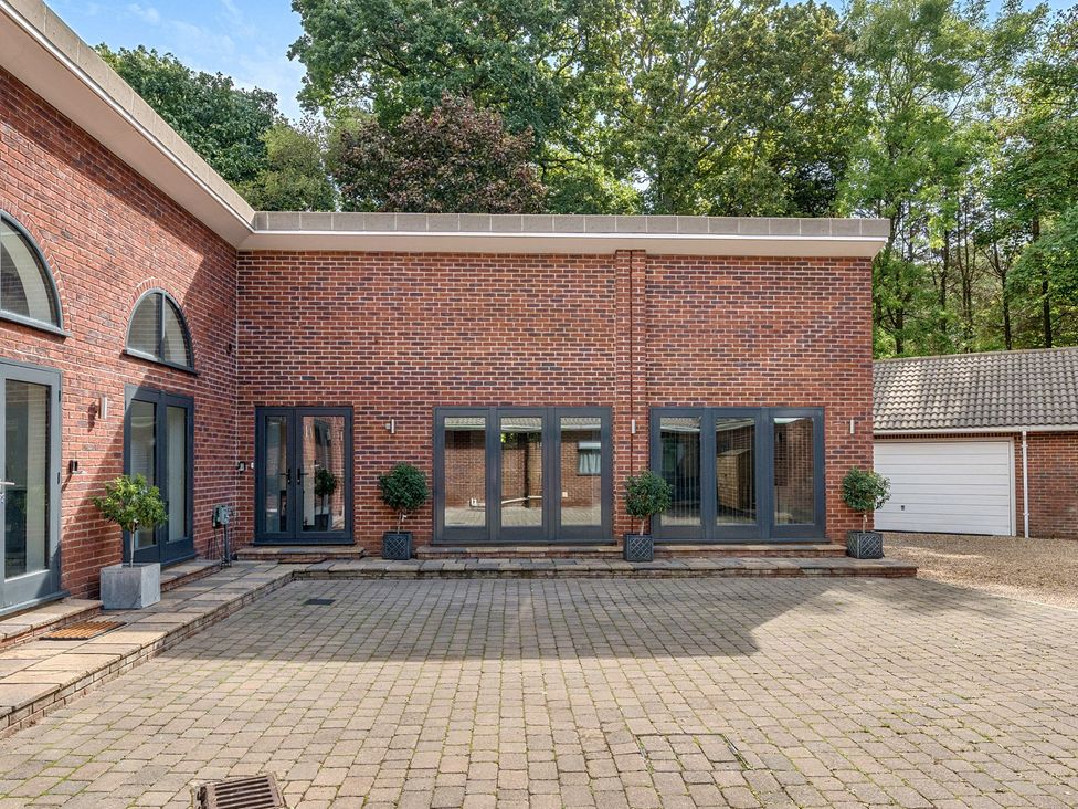 An outdoor area with brick walls and planters at The Cottage in Wimborne Minster