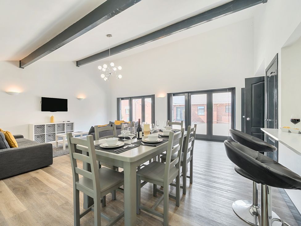 A living room with dining area and sofa at The Cottage in Wimborne Minster