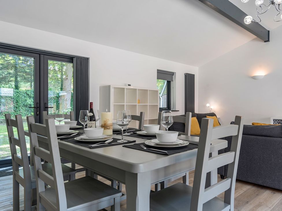 A dining room with a table set for dinner at The Cottage in Wimborne Minster
