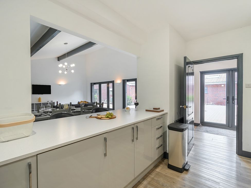 A kitchen with a kitchen island and stools at The Cottage in Wimborne Minster
