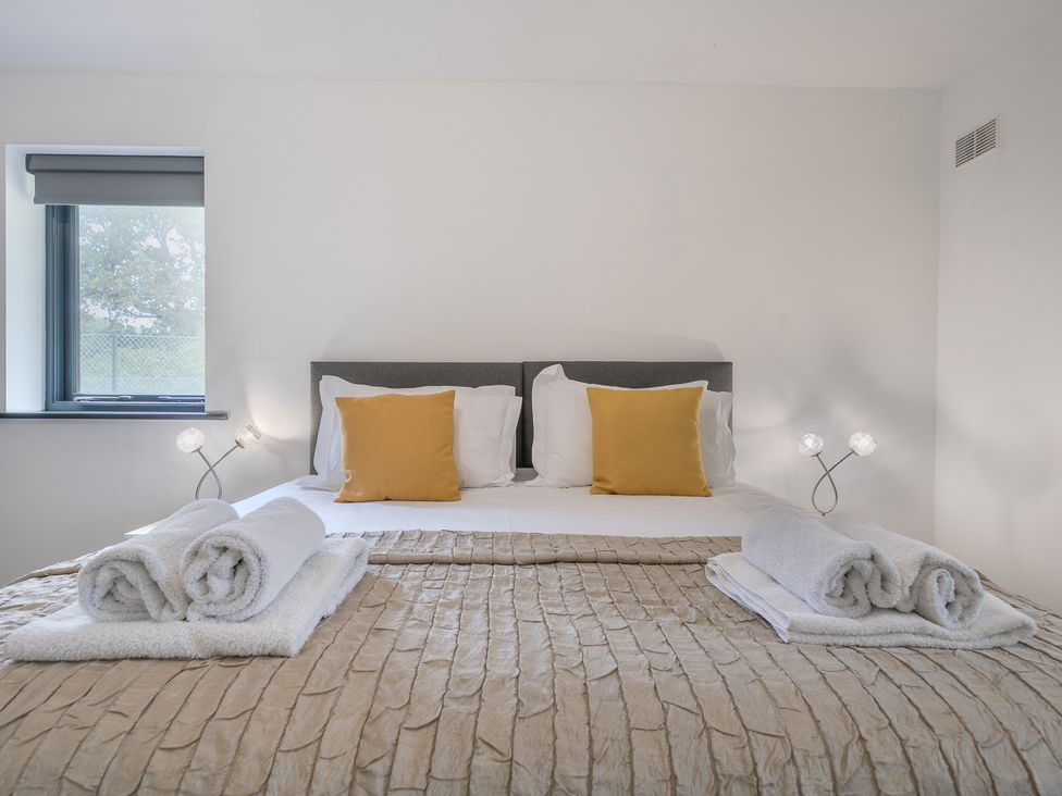 A bedroom with a bed and pillows at The Cottage in Wimborne Minster