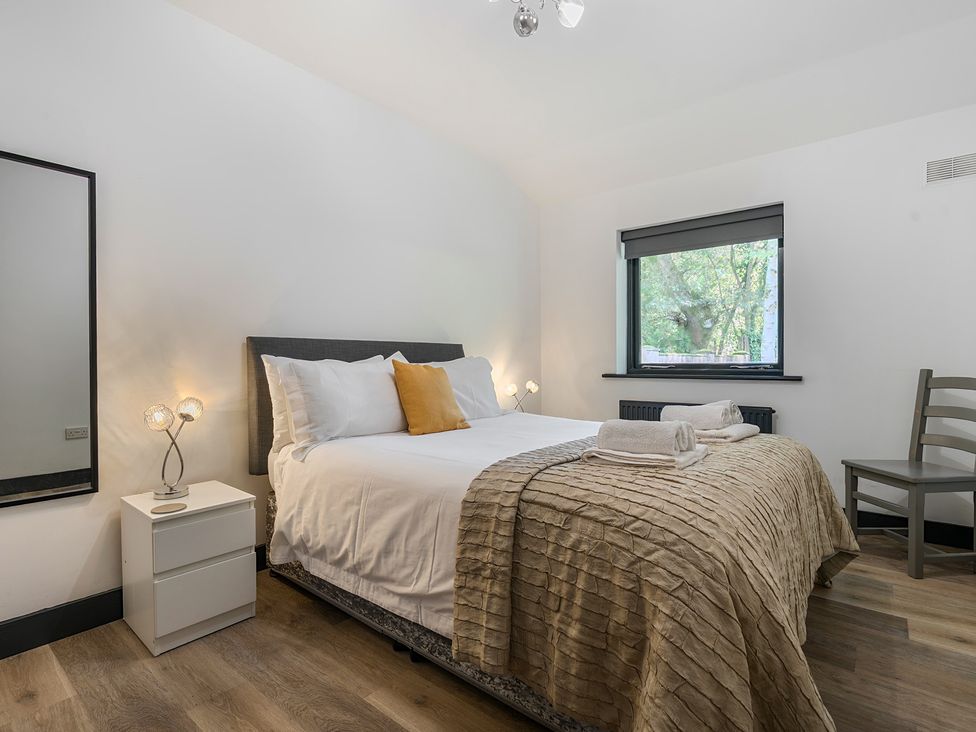 A bedroom with a bed and nightstand at The Cottage in Wimborne Minster