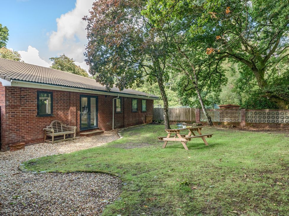 A garden with a bench and picnic table at The Cottage in Wimborne Minster