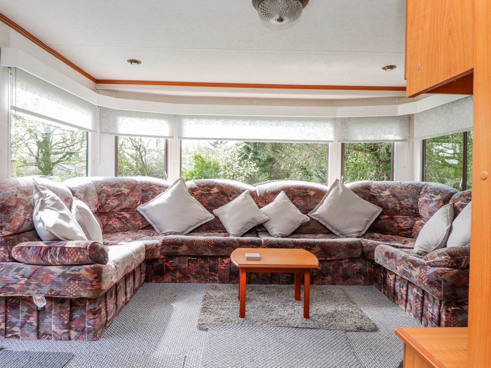 A living room with a sofa and coffee table at Fron Dderw Caravan Llanfairynghornwy near Llanfechell
