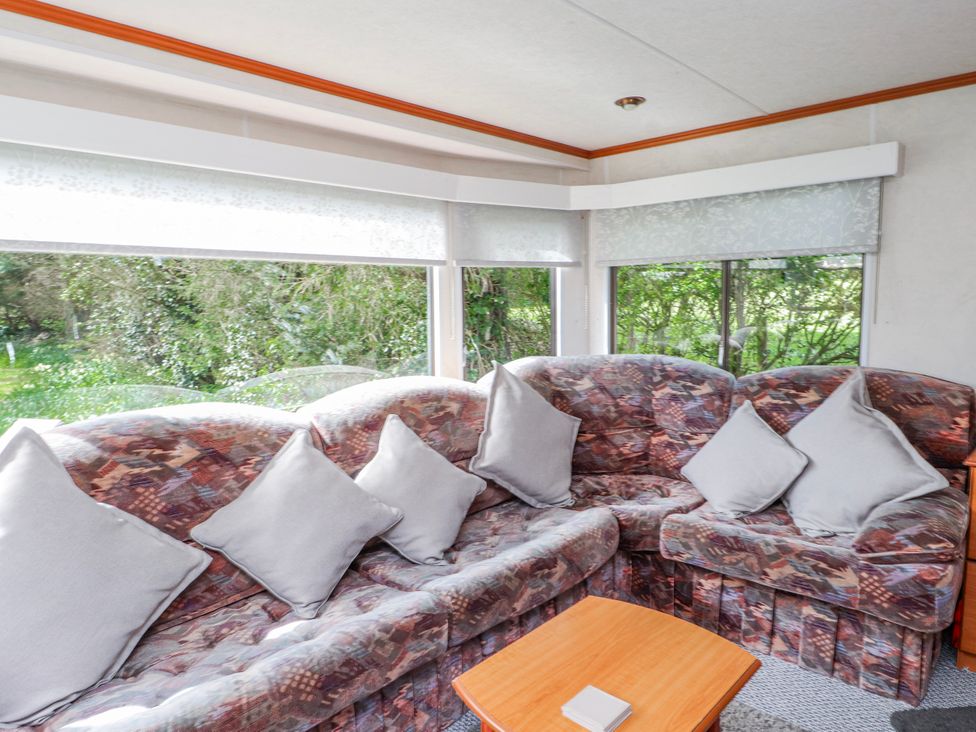 A snug with a sofa and coffee table at Fron Dderw Caravan Llanfairynghornwy near Llanfechell