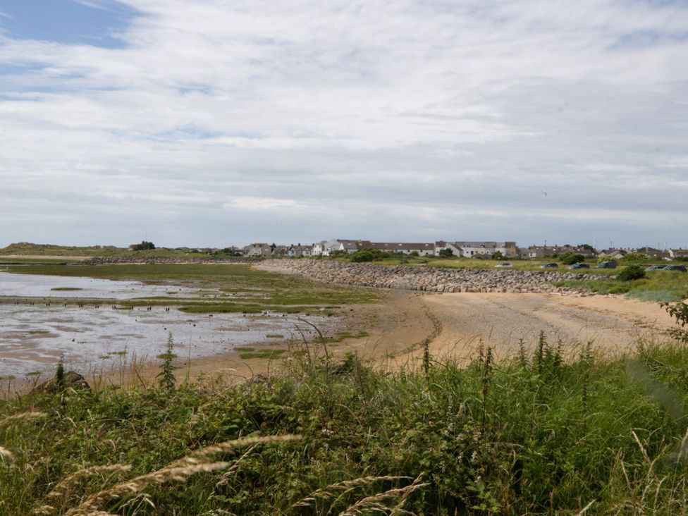 A beach view with water and houses at Harbour Retreat in Haverigg