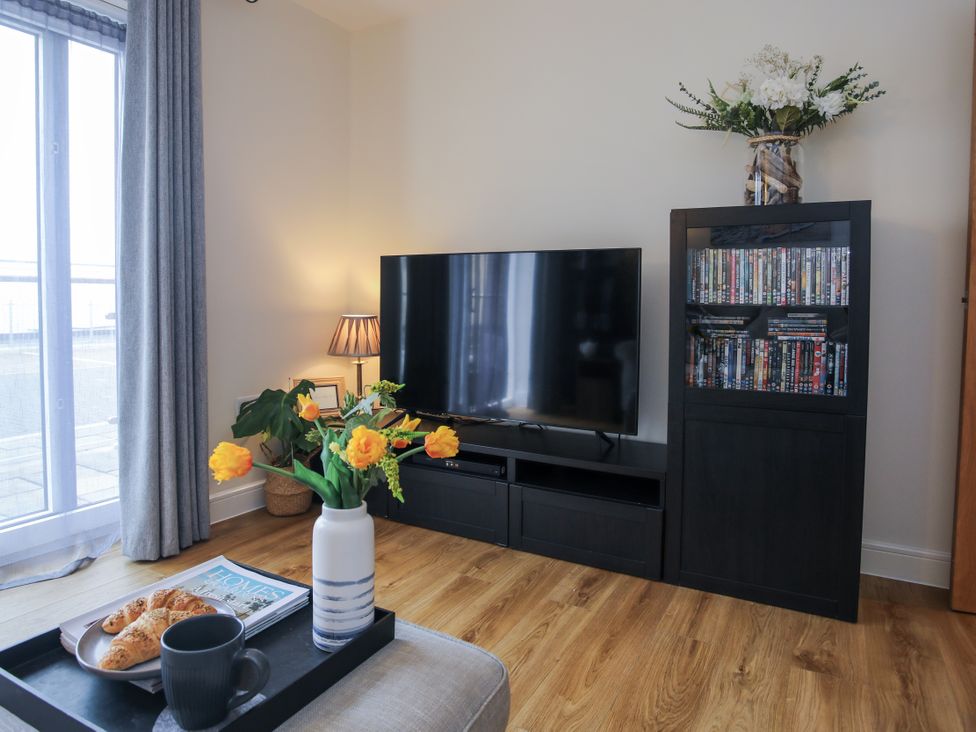 A living room with a television and coffee table at Apartment 3 in Trearddur Bay