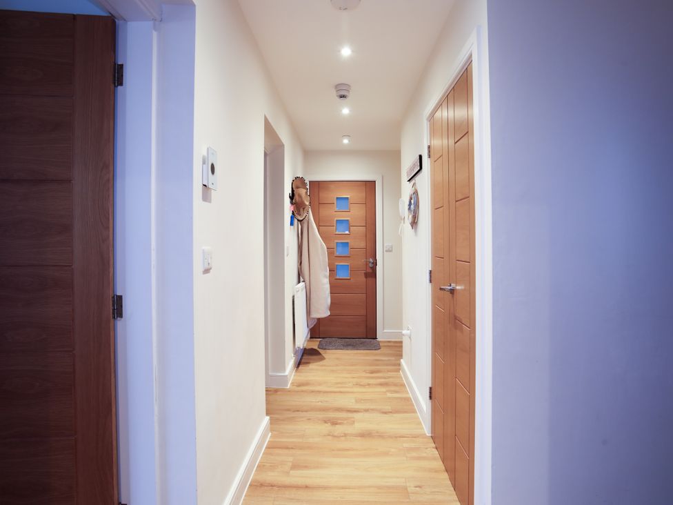 A hallway with doors and a rug at Apartment 3 in Trearddur Bay