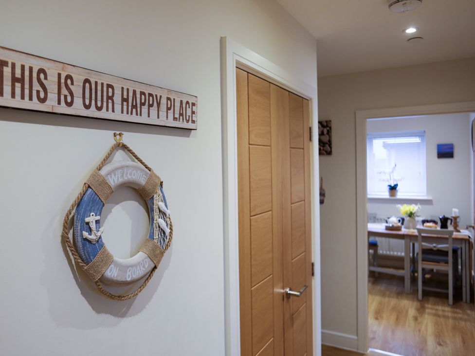A hallway with a wreath and a sign at Apartment 3 in Trearddur Bay
