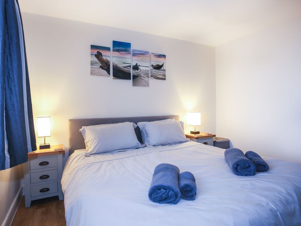 A bedroom with a bed and bedside tables at Apartment 3 in Trearddur Bay