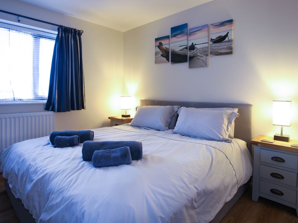 A bedroom with a bed and towels at Apartment 3 in Trearddur Bay