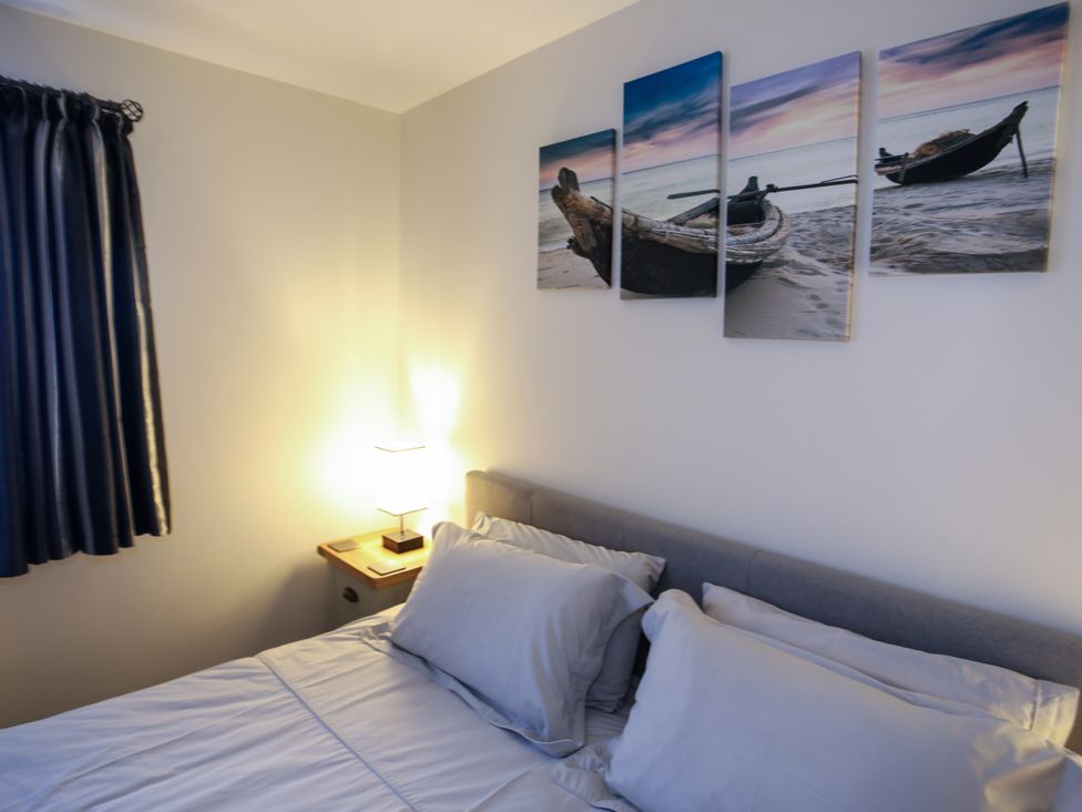 A bedroom with a bed and wall art at Apartment 3 in Trearddur Bay