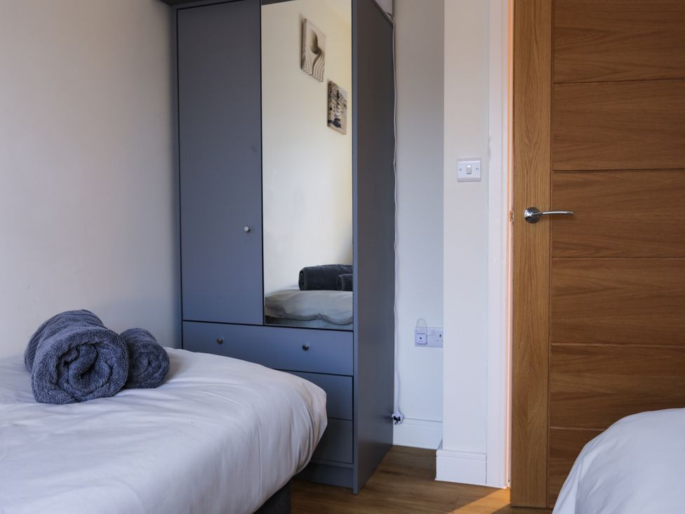 A bedroom with a bed and wardrobe at Apartment 3 in Trearddur Bay