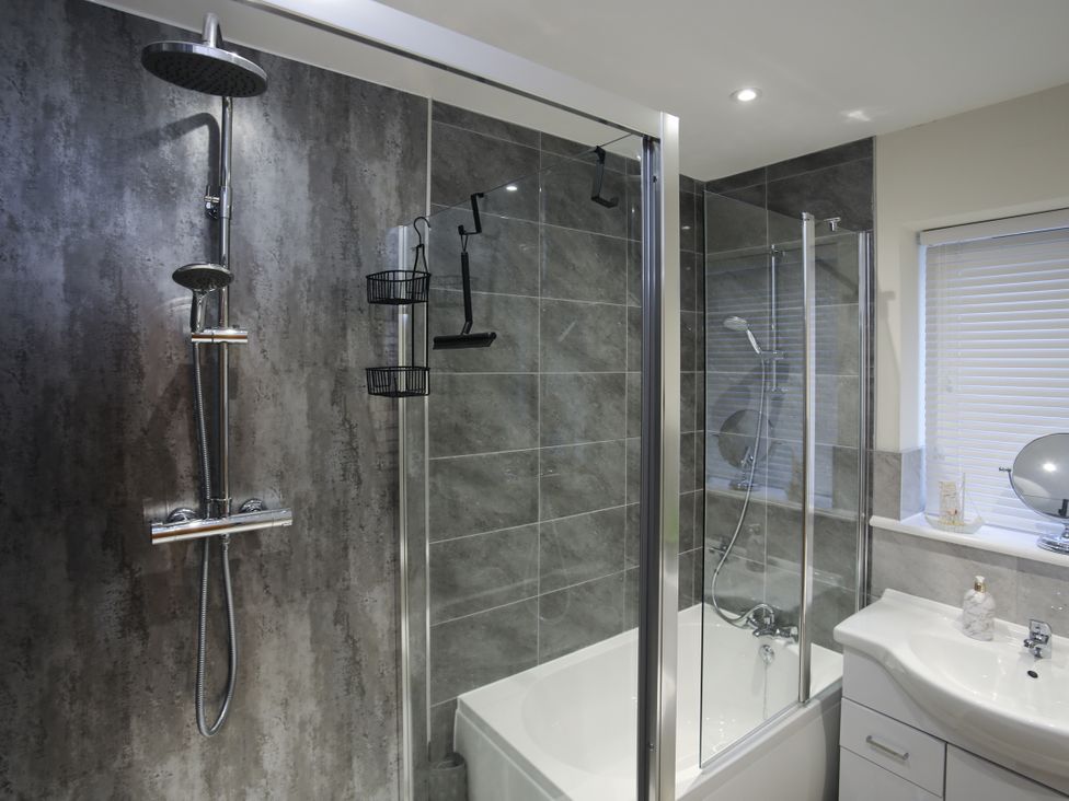 A bathroom with a shower and bathtub at Apartment 3 in Trearddur Bay