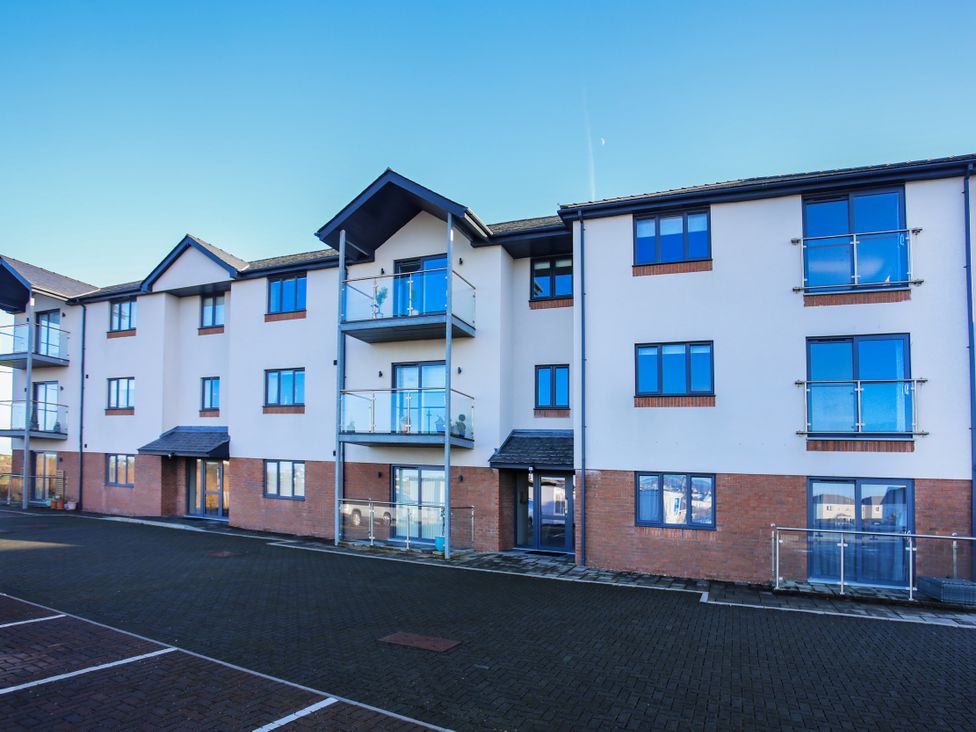 A residential building with balconies and parking area at Apartment 3 Trearddur Bay