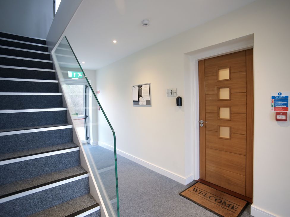 A hallway with stairs and a door at Apartment 3 in Trearddur Bay