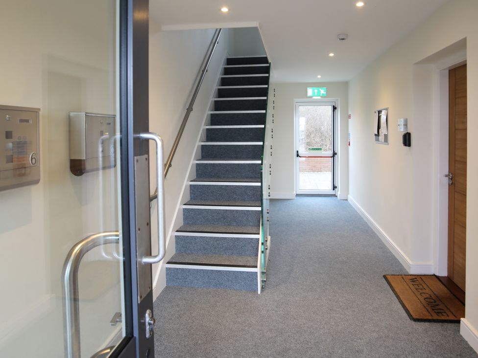 A hallway with a staircase and mailboxes at Apartment 3 Trearddur Bay