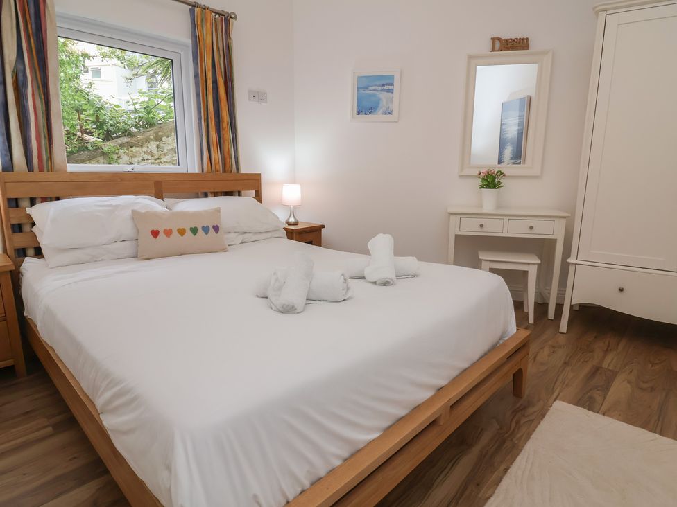A bedroom with a bed and desk at 11 Cove View Apartments Ilfracombe