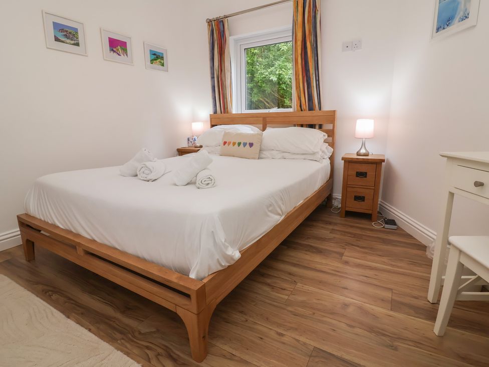 A bedroom with a bed and nightstand at 11 Cove View Apartments Ilfracombe