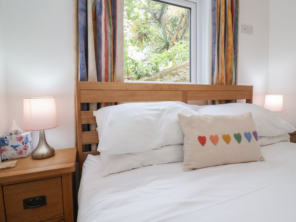 A bedroom with a bed and a pillow at 11 Cove View Apartments Ilfracombe