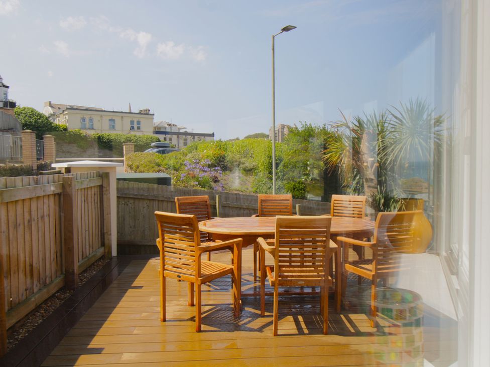 An outdoor dining area with wooden furniture at 11 Cove View Apartments Ilfracombe