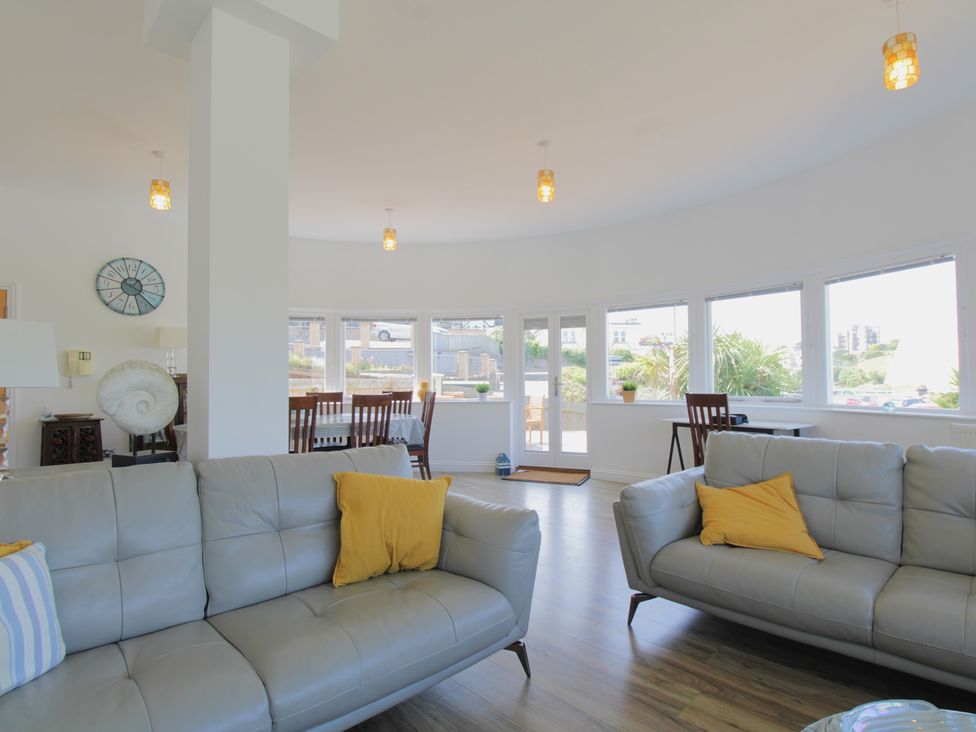 A living room with sofas and a dining area at 11 Cove View Apartments in Ilfracombe