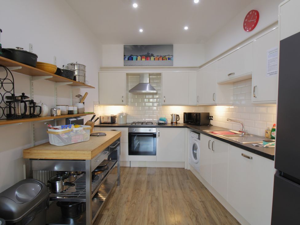 A kitchen with appliances and shelves at 11 Cove View Apartments Ilfracombe