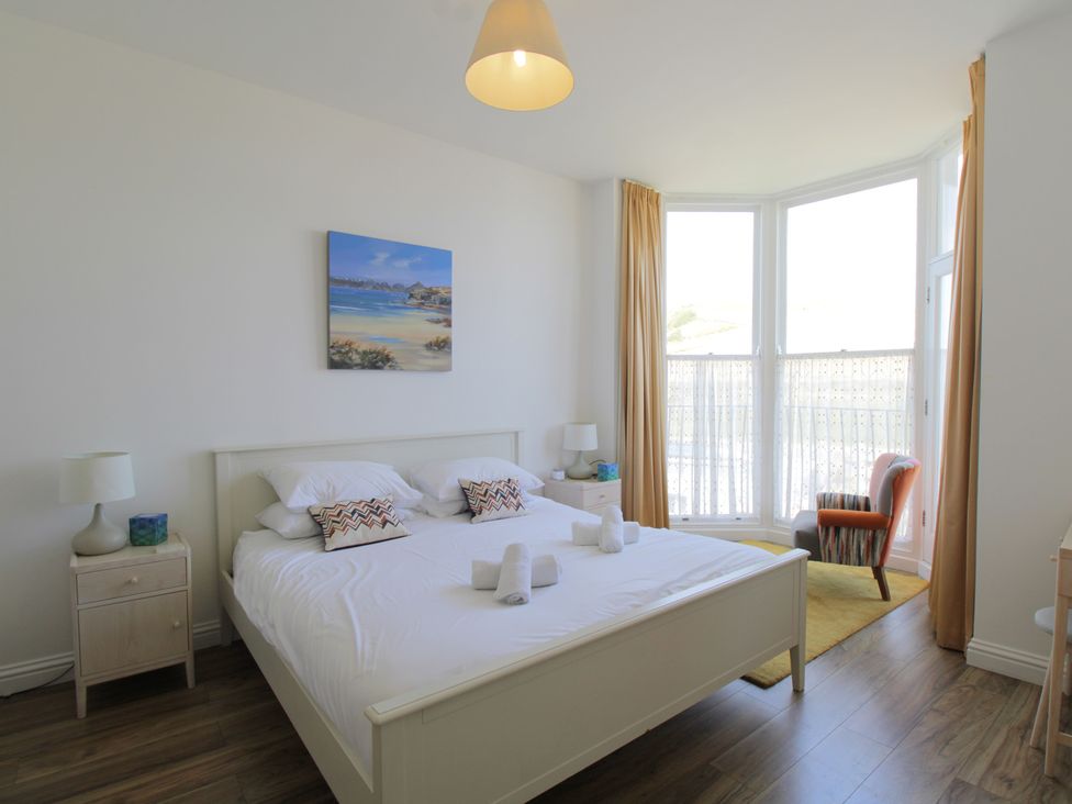 A bedroom with a bed and nightstands at 11 Cove View Apartments Ilfracombe