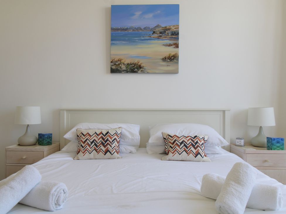 A bedroom featuring a bed with pillows and towels at 11 Cove View Apartments Ilfracombe