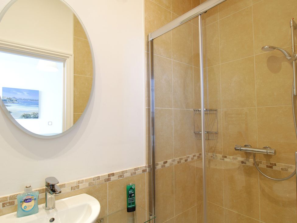 A bathroom with a shower and sink at 11 Cove View Apartments in Ilfracombe