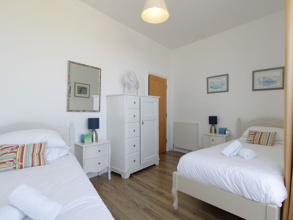A bedroom with two beds and a dresser at 11 Cove View Apartments Ilfracombe