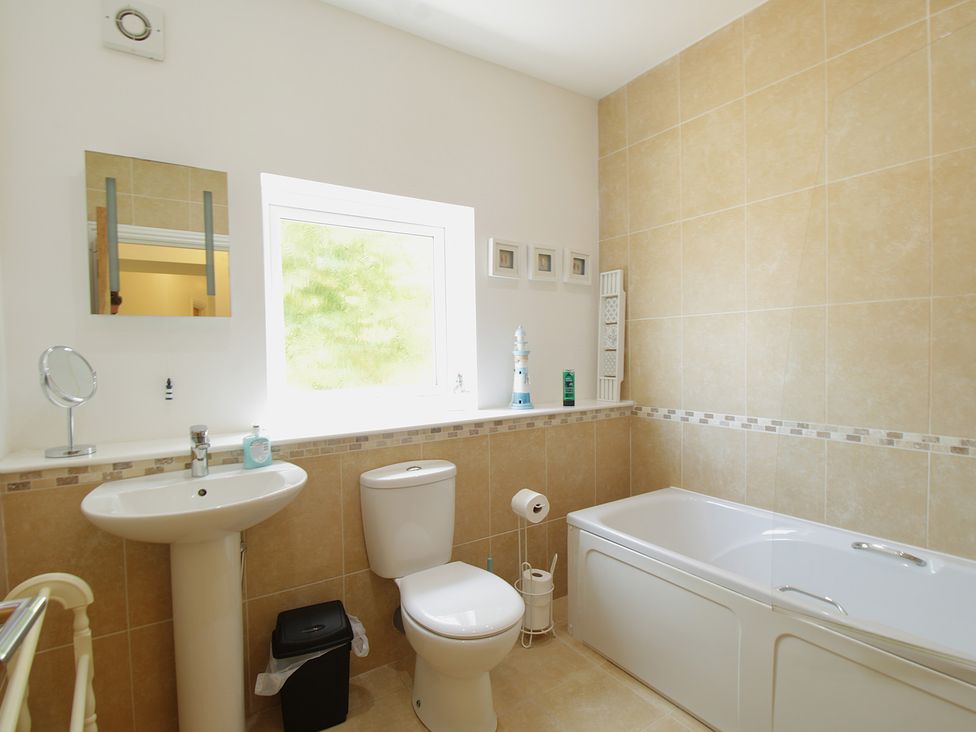 A bathroom with a sink, toilet, and bath at 11 Cove View Apartments in Ilfracombe