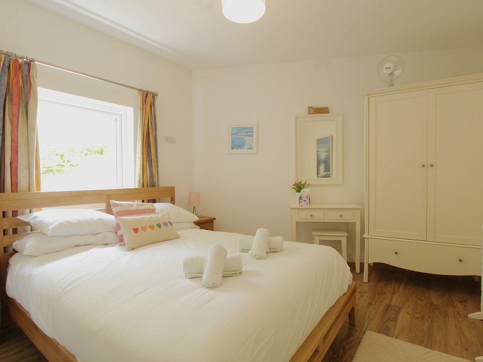 A bedroom with a bed and desk at 11 Cove View Apartments Ilfracombe