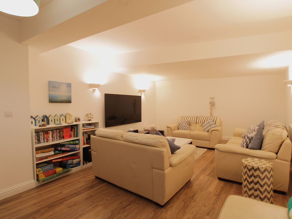 A living room with a tv and bookshelf at 11 Cove View Apartments in Ilfracombe