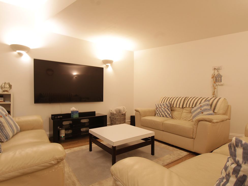 A living room with a television and sofas at 11 Cove View Apartments Ilfracombe