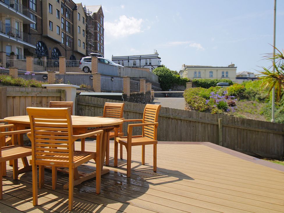 An outdoor seating area with a table and chairs at 11 Cove View Apartments Ilfracombe