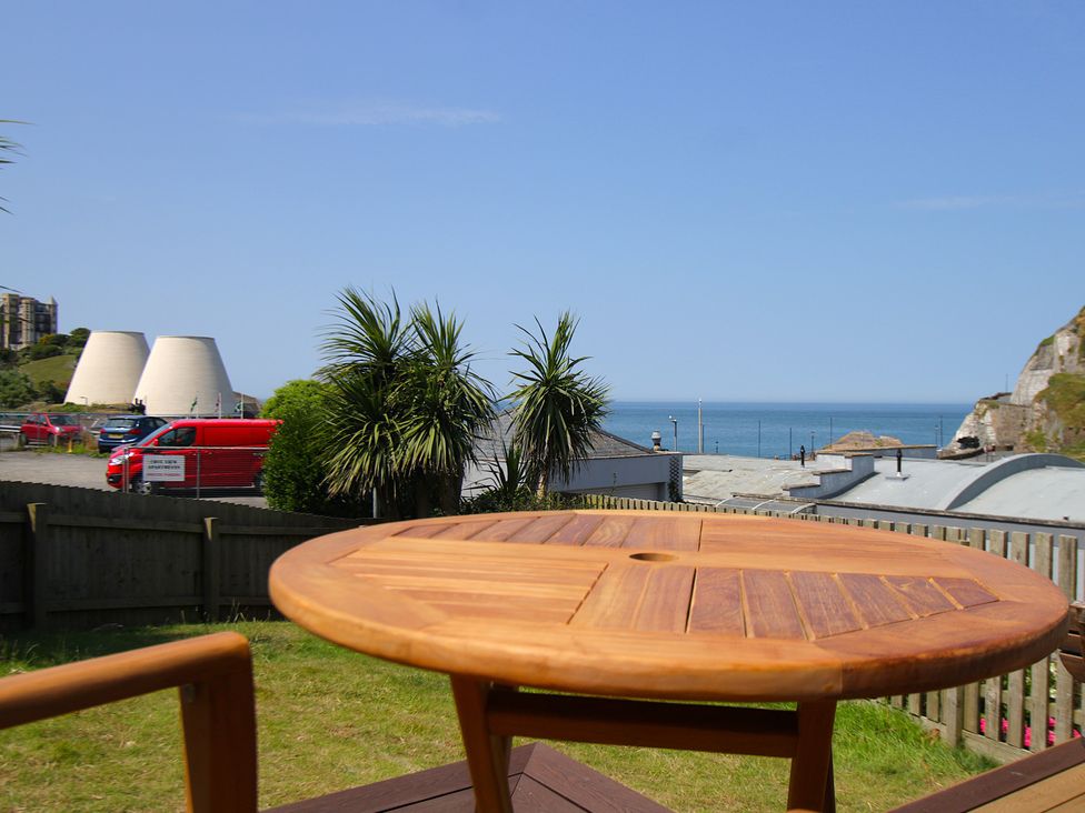 An outdoor view featuring a wooden table and the sea at 11 Cove View Apartments in Ilfracombe