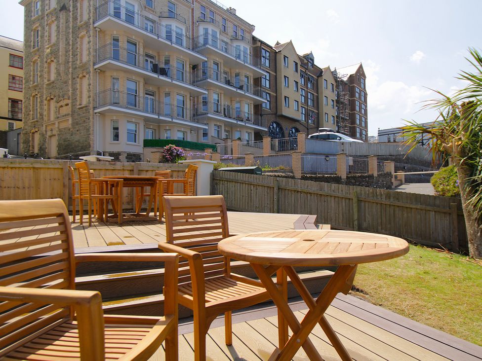 A deck area with tables and chairs at 11 Cove View Apartments in Ilfracombe