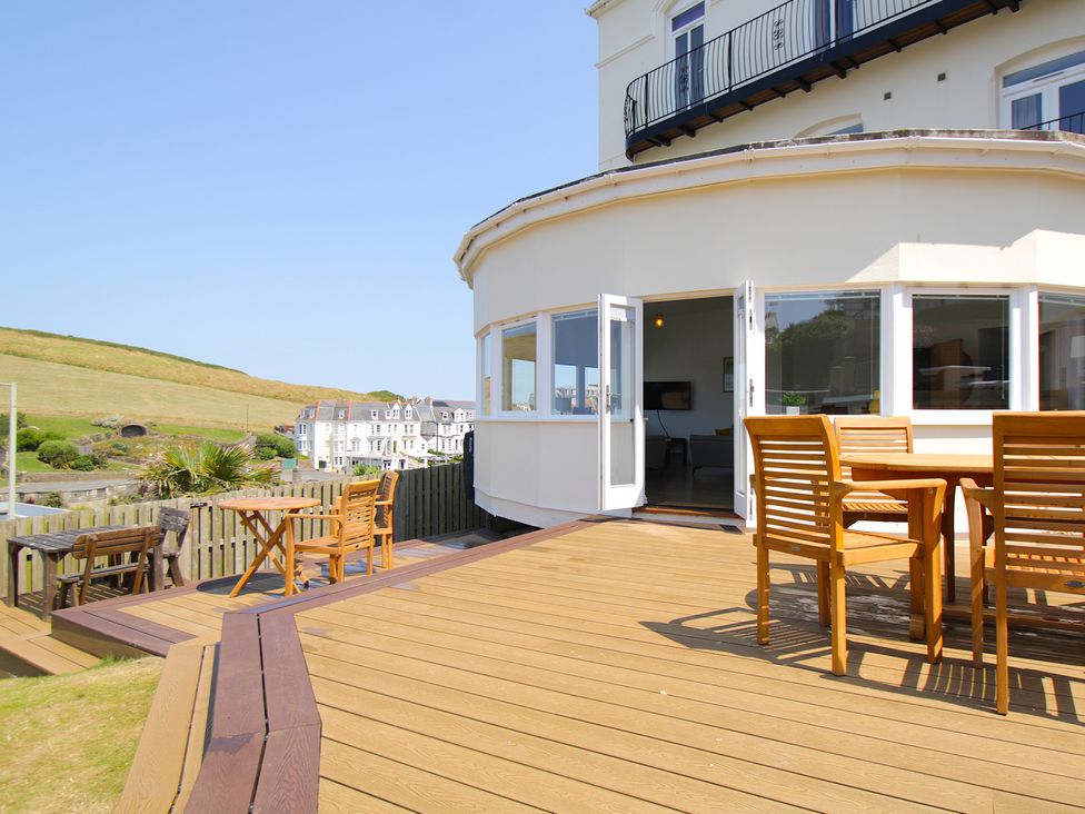 An outdoor area with a deck, table, and chairs at 11 Cove View Apartments Ilfracombe