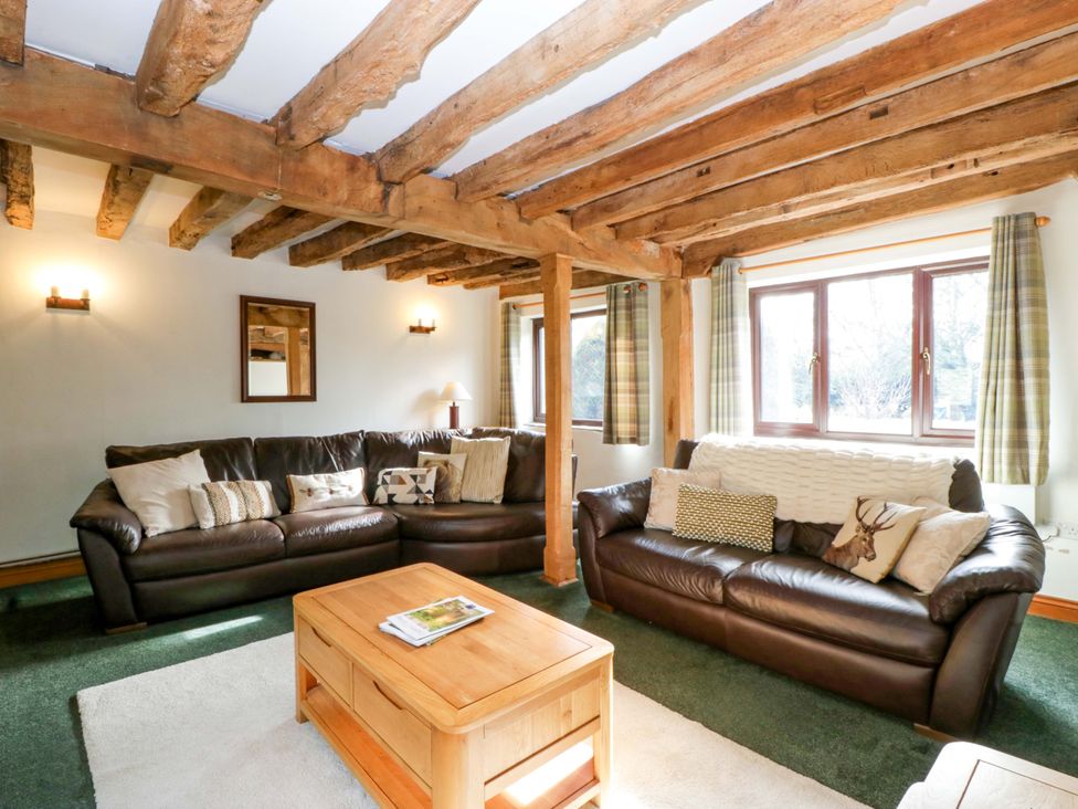 A living room with sofas and a coffee table at Redstart Cottage in Kingsland
