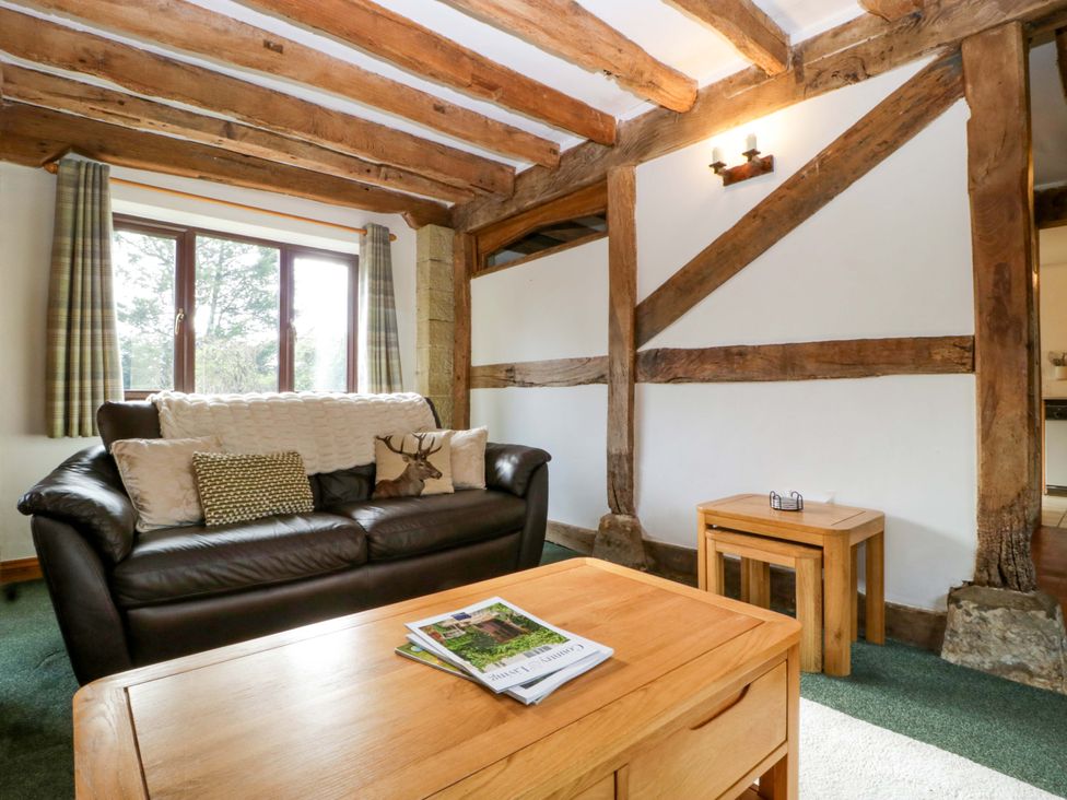 A living room with a sofa and coffee table at Redstart Cottage in Kingsland