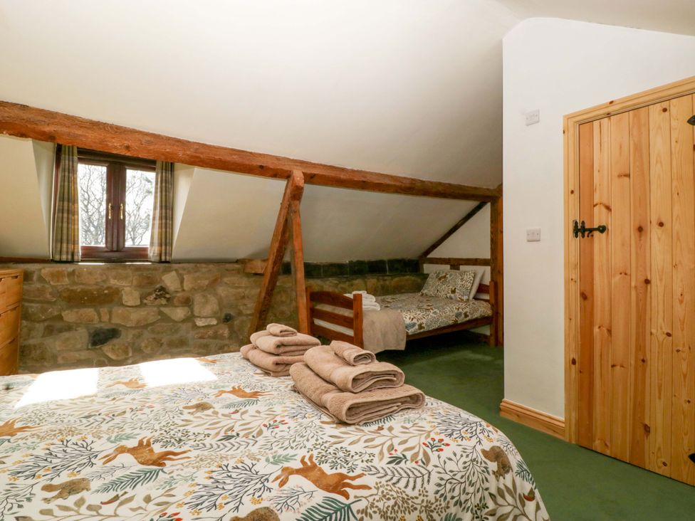 A bedroom with a bed and bunk bed at Redstart Cottage in Kingsland