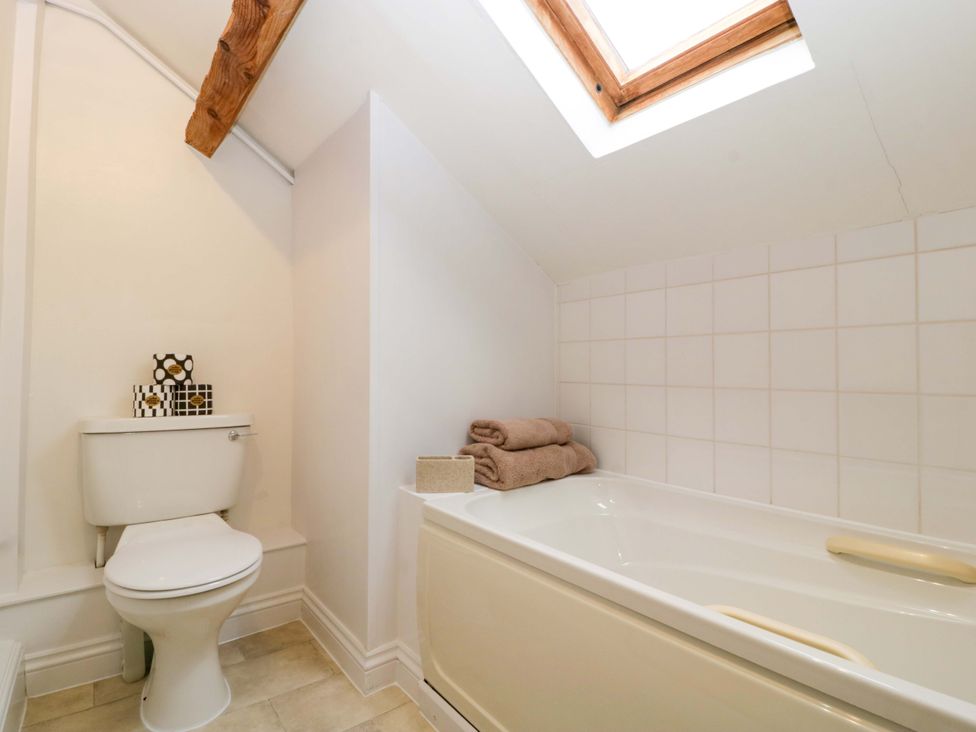 A bathroom with a toilet and bathtub at Redstart Cottage in Kingsland