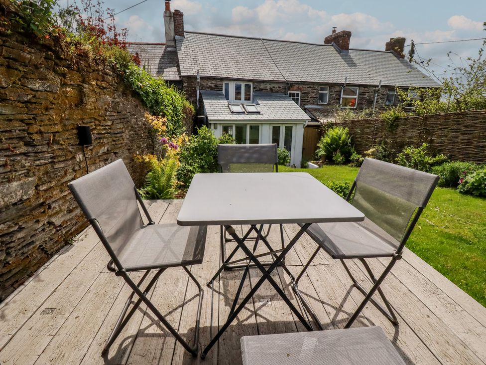 A garden with a table and chairs at Gwynn Cottage, St Mabyn
