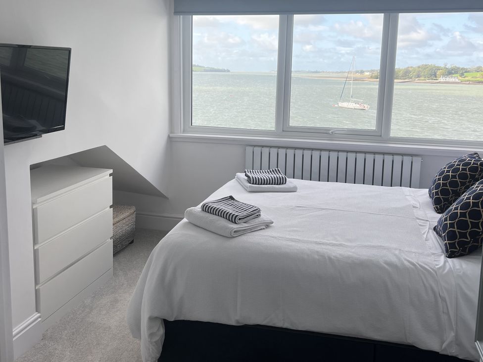 A bedroom with a bed and television at White Sails Y Felinheli
