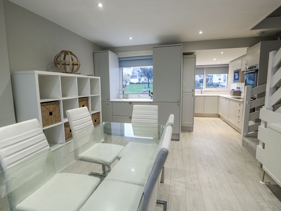 A kitchen with a dining table and chairs at White Sails in Y Felinheli
