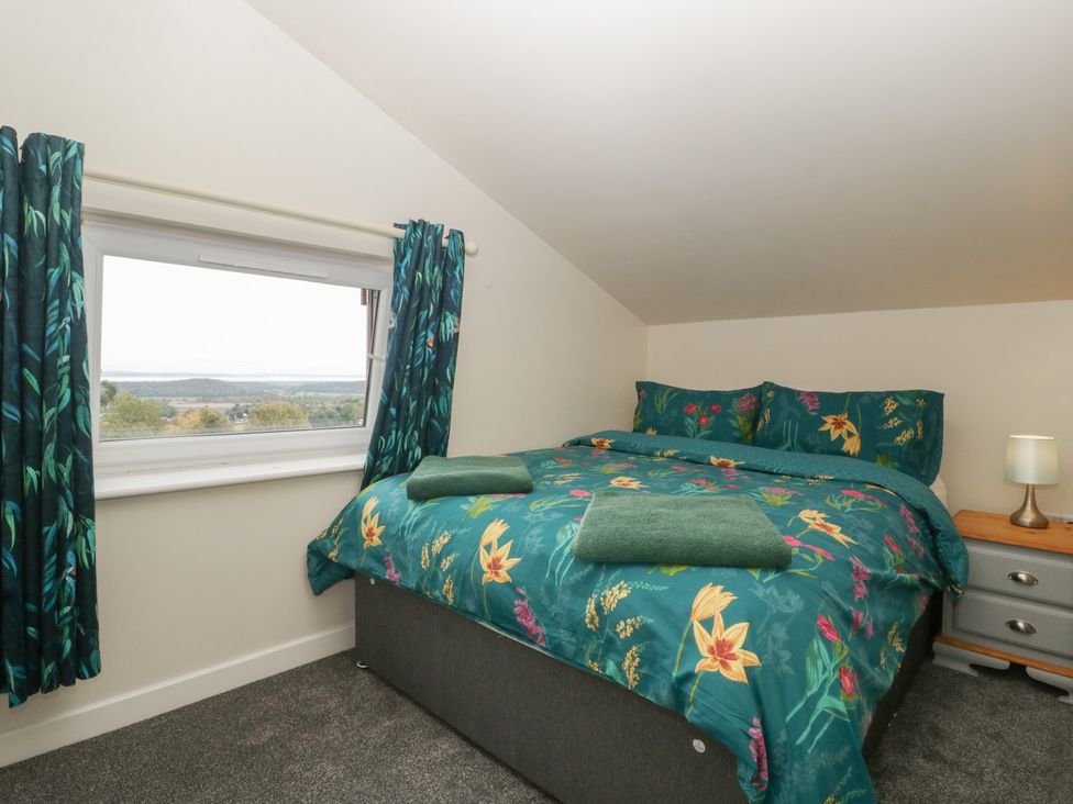 A bedroom with a bed and a window at Top Lodge Llanvair-Discoed near Penhow