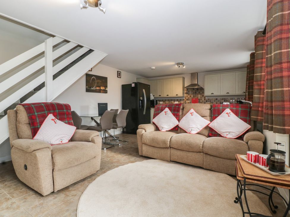 A living room with a sofa and dining area at Top Lodge in Llanvair-Discoed near Penhow