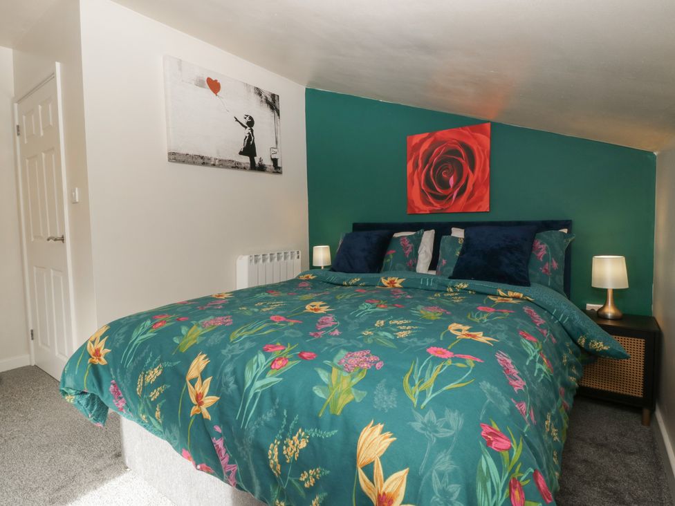 A bedroom with a bed and wall art at Top Lodge Llanvair-Discoed near Penhow