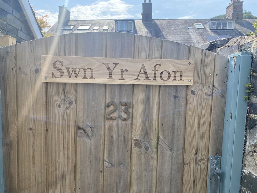 A wooden gate with a sign reading Swn Yr Afon and the number 23 at Swn Yr Afon Abergynolwyn near Tywyn